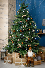 Modern design Christmas tree decorated with balls and garlands - navy blue, brown, beige. Winter holidays composition.