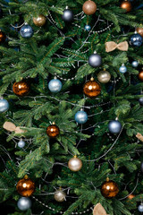 Modern design Christmas tree decorated with balls and garlands - navy blue, brown, beige. Winter holidays composition.