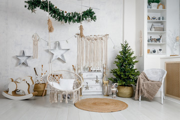 Modern interior design room with Christmas and New Year decorations, toys, gifts, fir tree, hanging swing. Winter holidays composition.