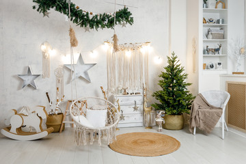 Modern interior design room with Christmas and New Year decorations, toys, gifts, fir tree, hanging swing. Winter holidays composition.