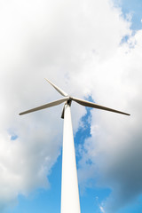 Wind turbine against a cloudy blue sky