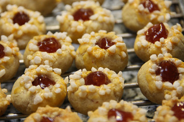 Traditional Austrian Husarenkrapferl lying on a grid Single sweet cookies with red marmalade decorated with sugar