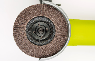 Angle grinder with abrasive disk on white background