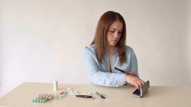Close-up of the girl changes the insulin cartridge in the insulin syringe pen before use. A diabetic patient makes a self-injection of insulin at home with a modern syringe pen.