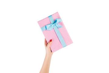 Woman hands give wrapped Christmas or other holiday handmade present in pink paper with blue ribbon. Isolated on white background, top view. thanksgiving Gift box concept
