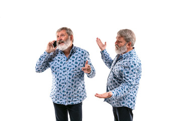 Senior man arguing with himself on white studio background. Concept of human emotions, expression, mental issues, internal conflict, split personality. Half-length portrait. Negative space. Inviting.