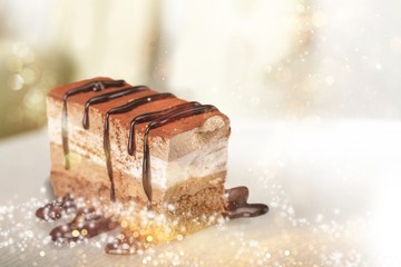 Slice of delicious chocolate cake on desk