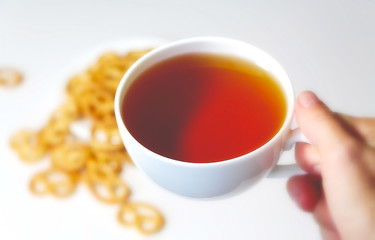  Cookies and tea. White cup of coffee. Morning. Breakfast. Pretzel. Bakery products. Dessert. Hot drink.