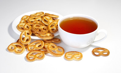  Cookies and tea. White cup of coffee. Morning. Breakfast. Pretzel. Bakery products. Dessert. Hot drink.