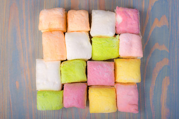multicolored marshmallow on a wooden blue background, top view