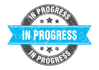 in progress round stamp with turquoise ribbon. in progress