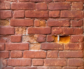 Closeup of old damaged brick wall with holes in place of some bricks
