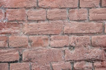 Texture of a brick wall coated with pink paint