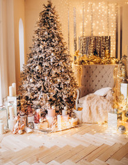 classical interior of a white room with a decorated fireplace, luxury Christmas tree, garlands, candles, lanterns, gifts. day golden pastel colors. new year