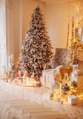 classical interior of a white room with a decorated fireplace, luxury Christmas tree, garlands, candles, lanterns, gifts. day golden pastel colors. new year