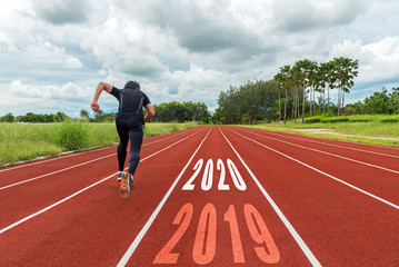 The start into the new year 2020. Start up of runner man running on race track go to Goal of Success.  People running as part of Number 2019 to 2020.  Holiday sport Concept