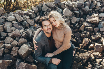 Couple in love embraced and sitting on stones