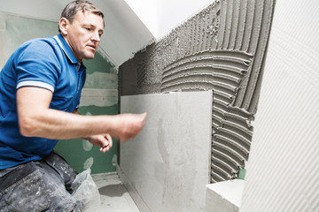 Fliesenleger in einem modernem badezimmer verlegt fliesen platten
