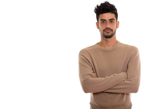 Studio shot of young Persian man with arms crossed