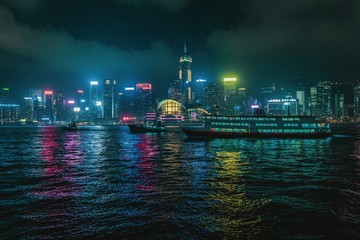 Naklejka premium Hongkong at night with skyline and tourist boat