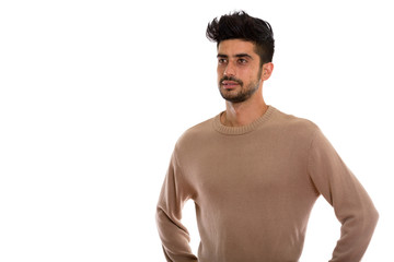 Studio shot of young Persian man thinking while looking at dista