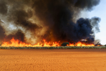 Bush fire in the Western Australian outback (Pilbara) with heavy, dark smoke. Bushfires are an...