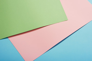 Color papers geometry flat composition background with green pink and blue tones