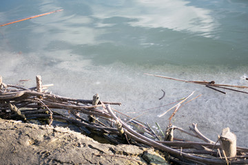 Fototapeta na wymiar driftwood on the icy part of the river