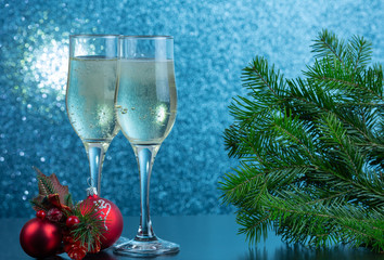 on the table are two glasses with champagne and New Year’s toys