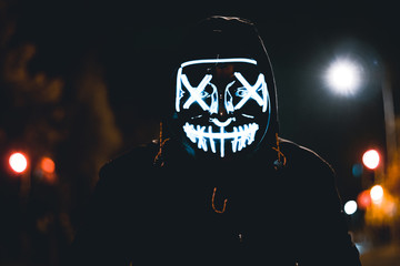 Blue LED halloween mask with a street background.