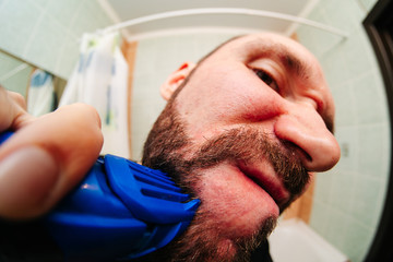 Obraz premium Man snarling at razor with shaving cream and towel