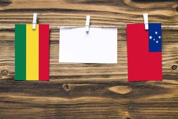 Hanging flags of Bolivia and Samoa attached to rope with clothes pins with copy space on white note...