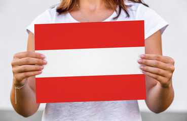 woman holds flag of Austria on paper sheet