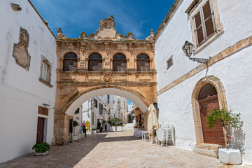 Fototapeta na wymiar Arco Scoppa, bridge in front of the cathedral connecting the two buildings: the Palace of the Bishop and Palazzo del Seminalio, Puglia, Italy.