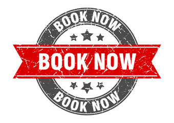 Obraz premium book now round stamp with red ribbon. book now