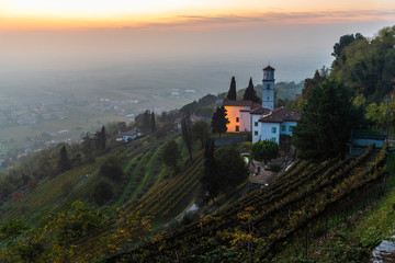 Sunset from the Cormons hill. Among fog, vineyards and fiery colors. Italy