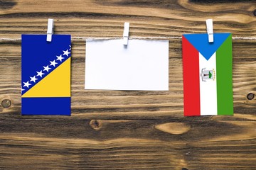 Hanging flags of Bosnia Herzegovina and Equatorial Guinea attached to rope with clothes pins with...