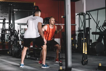  back view of personal trainer supervising young african american sportsman lifting barbell © LIGHTFIELD STUDIOS