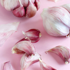 Fresh garlic on a light pink background