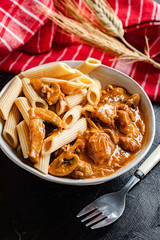 Penne pasta in pork sauce with mushroom.
