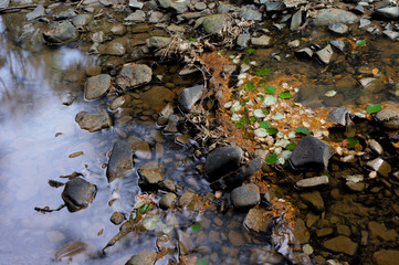 Stones on the background of the river with reflection of the sky