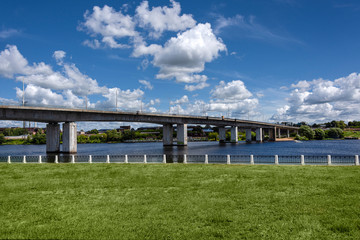 Fototapeta na wymiar Russia, Golden Ring, Kostroma: Panorama with big bridge over Kostroma River near famous Ipatievsky Monastery near the city center of the Russian town with blue cloudy sky - traffic.