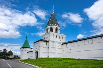 Russia, Golden Ring, Kostroma: Main entrance gate to the famous onion domed Ipatievsky Monastery opposite the city center of the Russian town with historic white wall, road and blue sky - architecture
