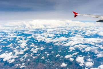 Fototapeta na wymiar Beautiful sky scape view from airplane window. Aeroplane wing view above thefluffy clouds, vivid sky and earth background. Holiday vacation and travelling concepts.
