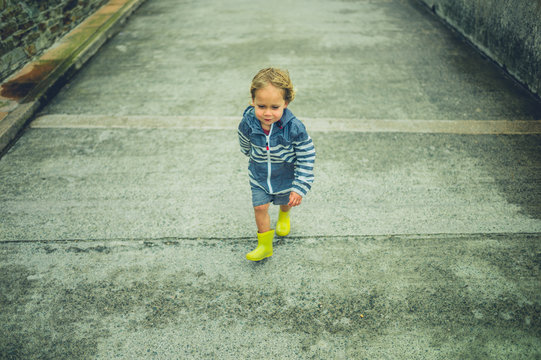 Little toddler running on concrete path