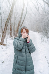A woman froze walking in a snowy forest