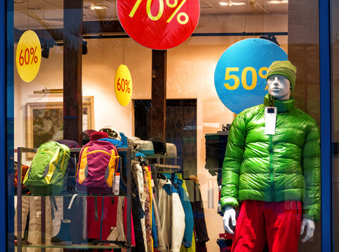 Shop window with store background. Fashion collection of winter or autumn sport clothes on mannequin and discount signs