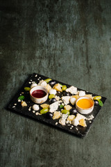 Cheese plate on a black table. Many kinds of cheese on a plate