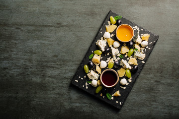 Cheese plate on a black table. Many kinds of cheese on a plate