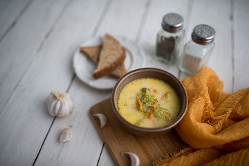 broccoli cheese soup served with toasted bread in a bowl